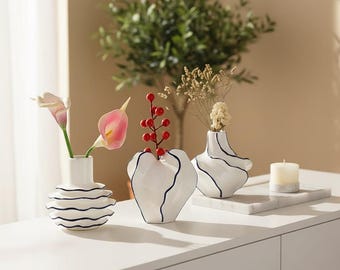 Falisty ceramiczny wazon: biały z niebieskim wykończeniem, nordycka wstążka dekoracyjna w centralnym punkcie
