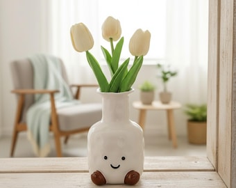 Ceramiczny wazon „Smiley Buziak”: teksturowana biała doniczka na nóżkach – eklektyczny akcent na biurko