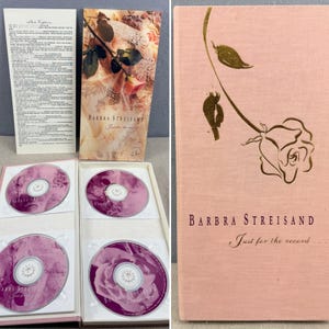 Puede incluir: Un box set de CD de Barbra Streisand. El set incluye cuatro CD con un diseño floral rosa y morado, un folleto y una caja rosa con el nombre del artista y el título del álbum. La caja presenta una ilustración de rosa dorada.