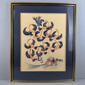 Peut inclure: Impression encadrée représentant une scène stylisée de personnes et d'oiseaux. L'œuvre utilise une palette de couleurs vives avec des nuances de bleu, d'orange et de beige. L'impression est encadrée dans un cadre doré avec un passe-partout bleu marine.