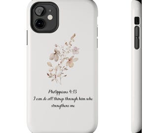 Pode incluir: Uma capa de telefone branca com um design floral em tons suaves de bege e rosa. A capa apresenta o texto "Filipenses 4:13" e "Tudo posso naquele que me fortalece" em escrita preta. A capa tem uma lente de câmera preta e botões laterais.
