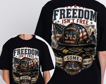 May include: Black t-shirt with a graphic design featuring a firefighter's helmet with an American flag motif, the text "FREEDOM ISN'T FREE," and the FDNY logo. The design includes the text "ALL GAVE SOME, SOME GAVE."
