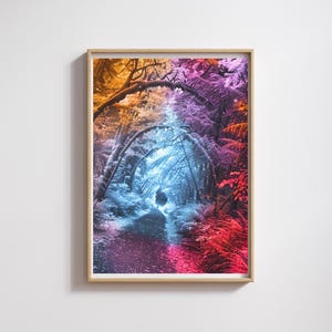 May include: A framed art print featuring a vibrant, surreal forest scene. The image showcases a tunnel-like path through trees, with colors ranging from orange and purple to blue and red. The artwork is encased in a light brown wooden frame.