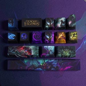Può includere: Un set di tasti personalizzati per tastiera meccanica con il marchio League of Legends e varie illustrazioni di personaggi. La collezione include una barra spaziatrice nera, tasti modificatori e tasti lettera decorati con vivaci grafiche viola, blu e oro.