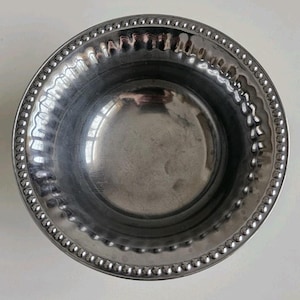 Puede incluir: Un cuenco redondo de acero inoxidable con borde de cuentas. El borde presenta un dise&ntilde;o festoneado y el interior es liso y reflectante. Este cuenco es adecuado para servir o decorar.