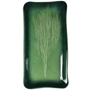 May include: A rectangular ceramic tray with a glossy finish in shades of deep forest green. The center features an embossed, detailed impression of a pine needle branch, with the glaze appearing darker along the edges and lighter in the center.