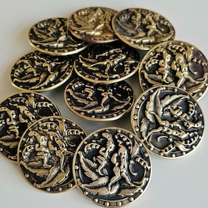 May include: A collection of antique brass-colored buttons. Each button features a detailed relief design of figures and foliage. The buttons have a dark, aged appearance, with intricate detailing around the edges. The buttons are round and vary slightly in size.