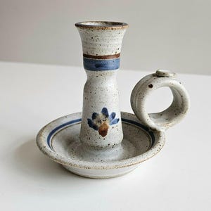 May include: A white ceramic mug with a black handle and the text "But First, Coffee" in a handwritten style. The mug is on a white surface. The mug is 4 inches tall.