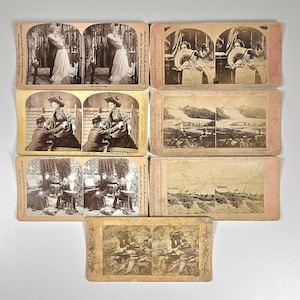 May include: A collection of seven rectangular stereoview cards featuring sepia-toned photographic prints. Each card displays two nearly identical images side-by-side, designed for viewing with a stereoscope, depicting various scenes and figures.