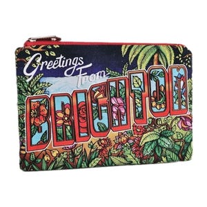 Pu&ograve; includere: Un portamonete rettangolare con chiusura a zip. Il design presenta le parole "Greetings From BRIGHTON" in stile cartolina vintage. Lo sfondo &egrave; blu scuro con illustrazioni floreali e di palme.
