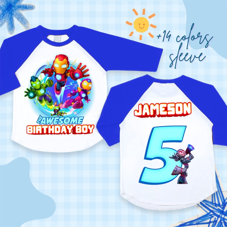 Puede incluir: Una camiseta blanca y azul de estilo ragl&aacute;n con un gr&aacute;fico colorido de personajes de dibujos animados y el texto "THE AWESOME BIRTHDAY BOY". La parte trasera de la camiseta tiene el nombre "JAMESON" y el n&uacute;mero "5".