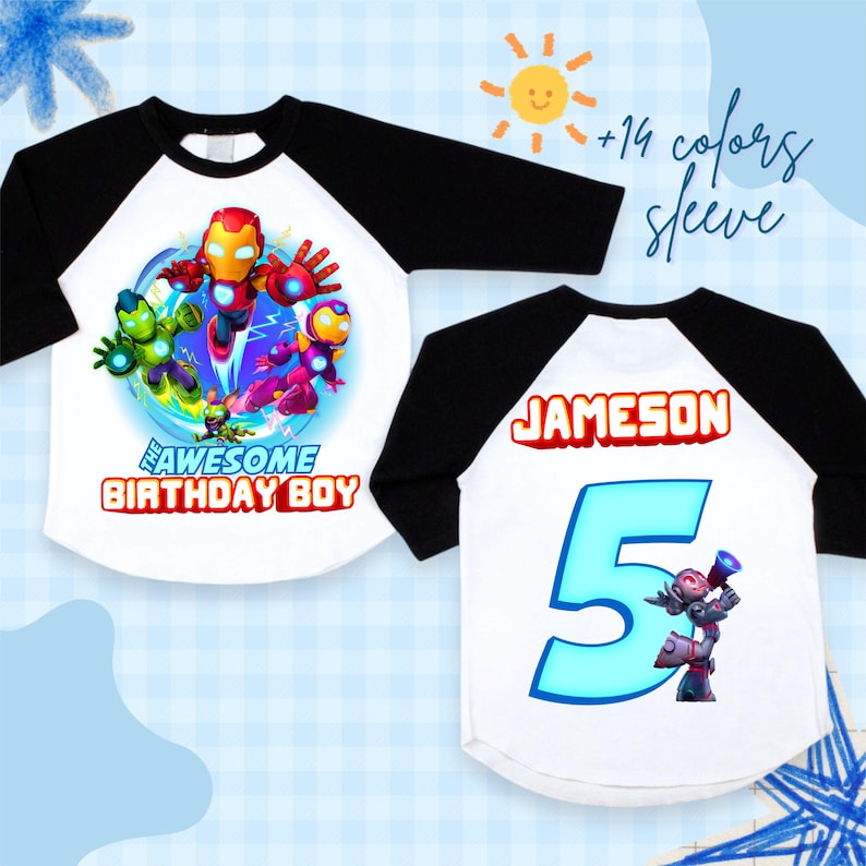 Puede incluir: Dos camisetas ragl&aacute;n blancas y negras con dise&ntilde;os de superh&eacute;roes. Una presenta un gr&aacute;fico de superh&eacute;roes colorido y el texto "THE AWESOME BIRTHDAY BOY". La otra camiseta muestra el nombre "JAMESON" y el n&uacute;mero "5".