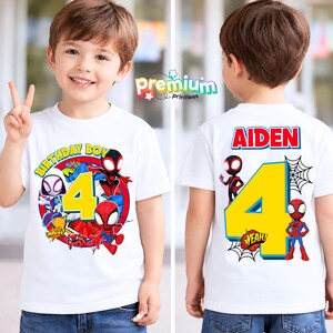 May include: White t-shirt featuring Spider-Man characters and the number 4. The front design includes the text "BIRTHDAY BOY" and "4". The back of the shirt displays the name "AIDEN" and the number 4, with Spider-Man graphics and a spider web.