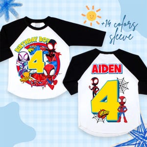 May include: White and black raglan-style t-shirts featuring Spider-Man characters. One shirt has "BIRTHDAY BOY" and the number "4" with comic book graphics. The other shirt has the name "AIDEN" and the number "4".