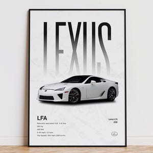 Könnte beinhalten: Ein gerahmter Druck mit einem weißen Lexus LFA Sportwagen. Das Wort "LEXUS" ist in großen, stilisierten Buchstaben über dem Auto zu sehen. Unter dem Auto sind Spezifikationen aufgeführt, einschließlich PS und einer Höchstgeschwindigkeit von 325 km/h.