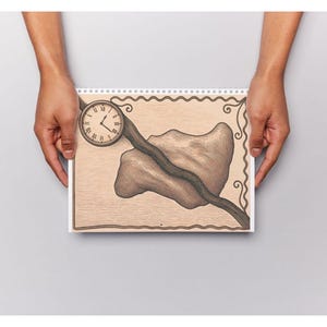 May include: A spiral-bound sketchbook featuring a tan-colored page with a hand-drawn illustration. The artwork depicts a circular analog clock with Roman numerals, a dark wavy line extending across the page, and a large, irregular brown shape.