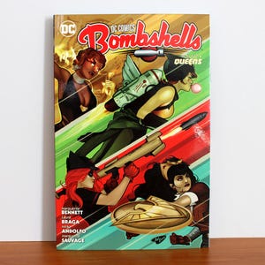 May include: DC Comics Bombshells Volume 4: Queens comic book cover. The cover features illustrations of female characters in action poses, with a retro comic book style. The color scheme includes red, green, yellow, and brown.