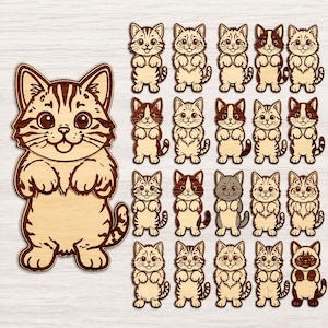 以下が含まれることがあります： 木製の猫の切り抜き20個のコレクション。それぞれに立ち姿の子猫が彫刻されています。左側に大きな切り抜きが1つあり、右側には19種類の小さな猫のデザインがグリッド状に配置されています。