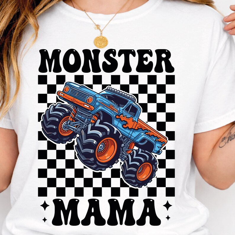 May include: White t-shirt featuring a blue and orange monster truck graphic with the text "MONSTER MAMA" in black. The design includes a checkered background.