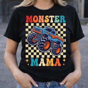May include: Black t-shirt featuring a retro design with the words "MONSTER MAMA" in orange, red, and teal. A blue and orange monster truck is centered on a checkered background. The shirt has short sleeves and a crew neck.