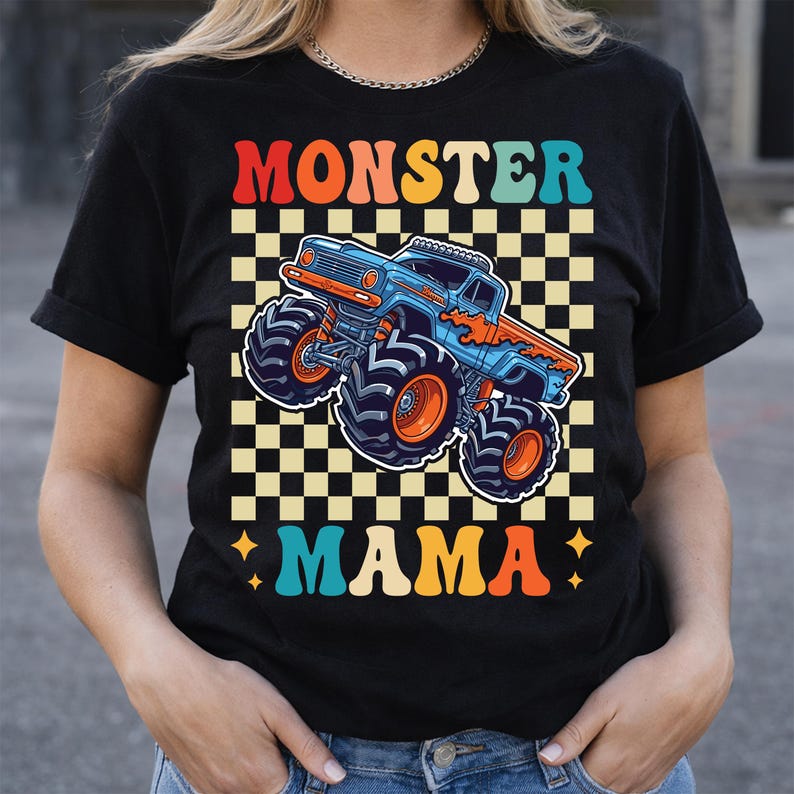 May include: Black t-shirt featuring a retro design with the words "MONSTER MAMA" in orange, red, and teal. A blue and orange monster truck is centered on a checkered background. The shirt has short sleeves and a crew neck.