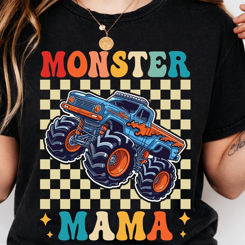 May include: Black t-shirt with a colorful graphic of a monster truck. The text "MONSTER MAMA" is displayed in a retro font above and below the truck. The truck is blue and orange, set against a checkered background.