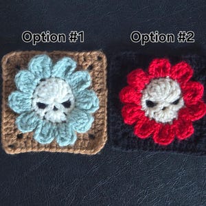 May include: Two crocheted squares with skull flower designs. Option #1 features a light blue flower on a brown square. Option #2 has a red flower on a black square. The skulls are white.