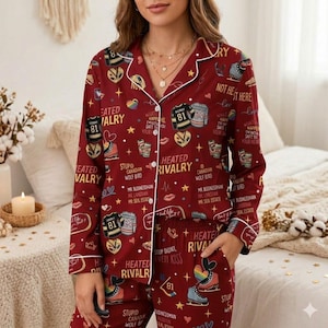 May include: Burgundy pajama set with white trim, featuring a repeating pattern of hockey skates, jerseys, and text. The text includes phrases like "Heated Rivalry" and "Stupid Canadian Wolf Bird".