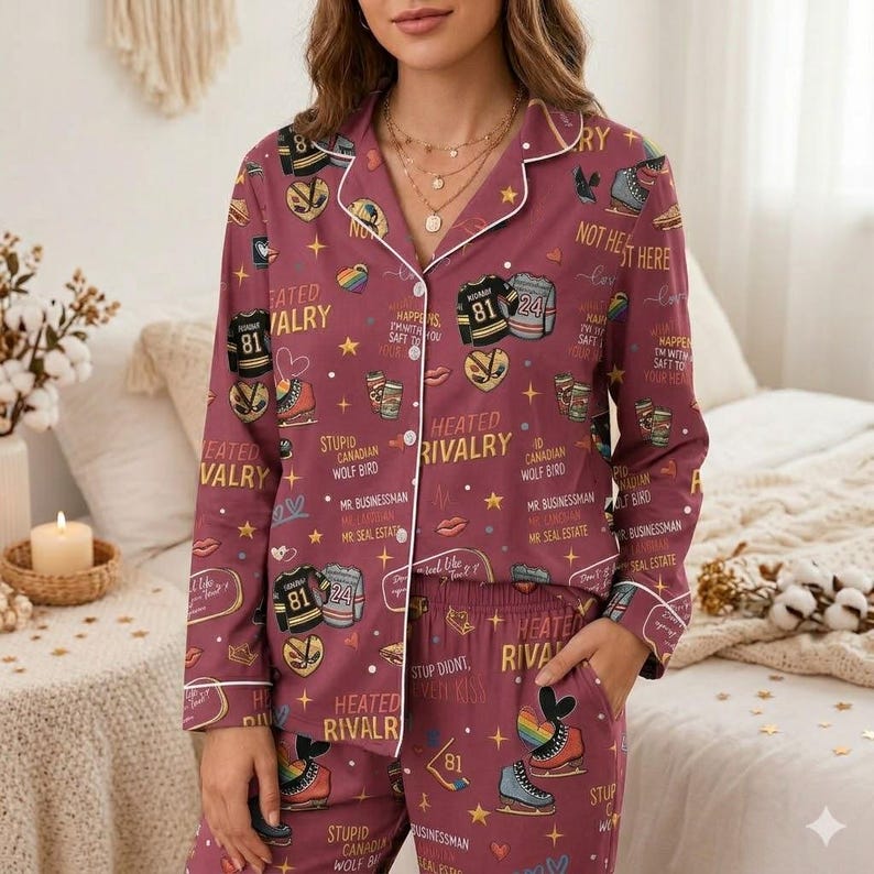 May include: Burgundy pajama set with a white trim, featuring a repeating pattern of ice skates, hockey jerseys, and text. The text includes phrases like "Heated Rivalry" and "Not Here".