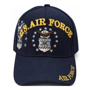 May include: Navy blue baseball cap with embroidered gold "U.S. AIR FORCE" text and emblem. The cap features a curved brim and a small embroidered design on the side. The words "AIR FORCE" are also embroidered on the brim.