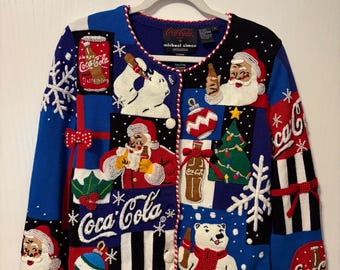 May include: A long-sleeve knit cardigan featuring a Coca-Cola theme with embroidered patches of Santa Claus, polar bears, Christmas trees, ornaments, and snowflakes. The sweater is multicoloured with blue, black, and white panels and button closures.