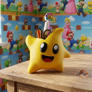 May include: A yellow star-shaped desk organizer with a smiling face and black eyes. The organizer holds pens, scissors, and a flower-shaped accessory. The background features a colorful wallpaper with cartoon characters.