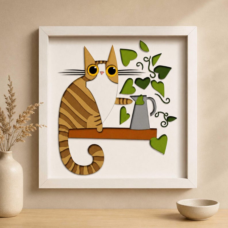 May include: A framed art piece featuring a stylized cat with brown and tan stripes, sitting on a brown shelf. Green heart-shaped leaves and a gray pitcher are also depicted. The artwork is set against a white background.