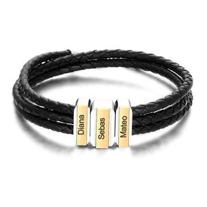 May include: Black braided leather bracelet featuring three silver and gold rectangular beads. Each bead is engraved with a name: "Diana", "Sebas", and "Mateo". The bracelet is made with three strands of braided leather.