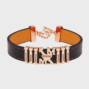 May include: A black leather bracelet with a gold clasp and accents. The bracelet features gold name charms with the names Jackson, Melba, Patrice, Emma, Conner, Sophia, and Michael. The interior of the bracelet is orange.
