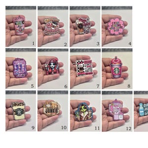 May include: A collection of thirteen acrylic pins featuring various designs including coffee cups, illustrated characters, and text-based graphics like 'Mom Juice', 'Sweet Tea Junkie', and 'Drink More Water', all rendered in vibrant pink, black, and multi-colored palettes.