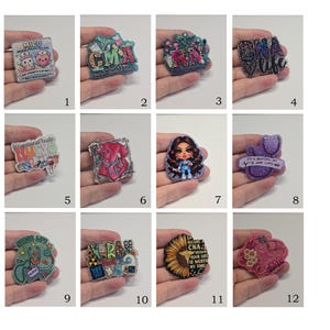 May include: A collection of twelve decorative acrylic badges featuring various medical themes, including illustrations of stethoscopes, scrubs, sunflowers, and text such as MICU, CNA, RN, and Nurse Life, each with a glittery finish and unique shapes.