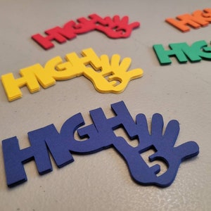 May include: A set of colorful foam cutouts that spell out "HIGH FIVE" with a hand shape. The cutouts are in red, yellow, green, blue, and pink.