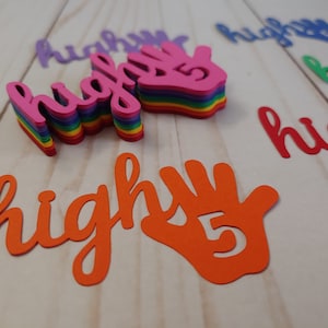 May include: A stack of colorful paper cutouts of the word "high five" with a hand cutout with the number 5 inside. The hand cutout is orange and the word "high five" is in various colors, including pink, purple, blue, green, and yellow.