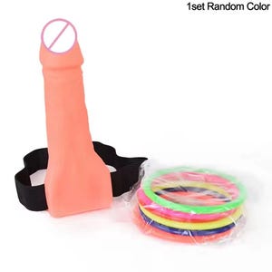 May include: A peach-colored sex toy with a black strap and a set of colorful rings. The text "1set Random Color" is visible in the upper right corner.