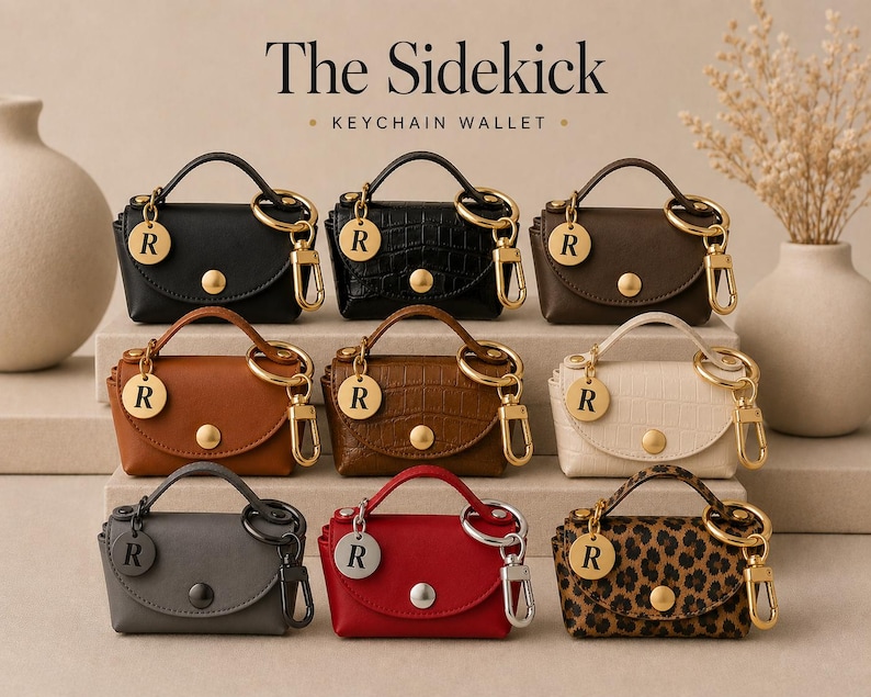 Puede incluir: Nueve carteras llavero en miniatura etiquetadas como The Sidekick, dispuestas en tres filas. Cada una cuenta con un asa superior, un bot&oacute;n a presi&oacute;n dorado o plateado y un dije circular con la letra R. Los colores incluyen negro, marr&oacute;n, tostado, crema, gris, rojo y estampado de leopardo.