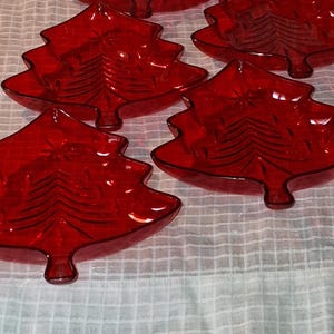 May include: A white ceramic mug with a black handle and the text "But First, Coffee" in a black, handwritten-style font. The mug is on a white surface.