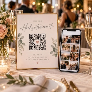 Könnte beinhalten: Ein goldgerahmtes Schild mit dem Text "UNSERE Hochzeitsmomente" und einem zentralen QR-Code mit einem kleinen Herzsymbol. Unter dem Code steht der Text "SCANNEN FOTOS HOCHLADEN GEMEINSAM ERINNERN". Ein Smartphone zeigt ein Raster mit Hochzeitsfotos.