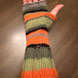 May include: Orange, green, black, and gray striped fingerless gloves knitted in a textured pattern.