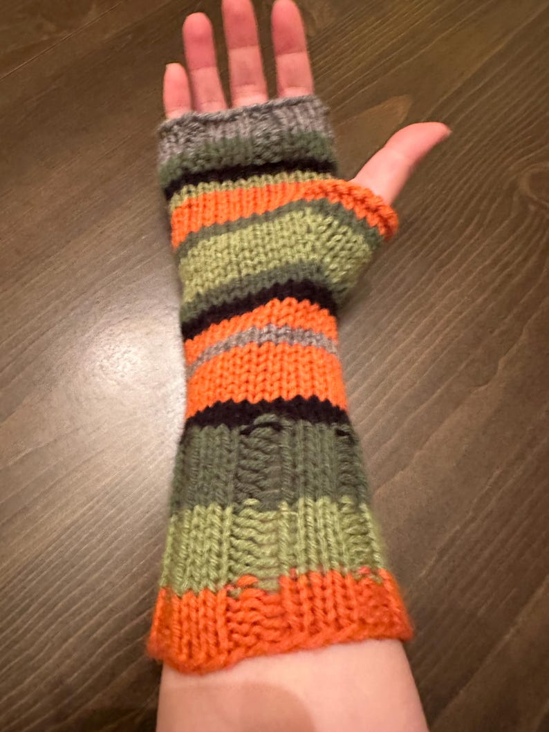 May include: Orange, green, black, and gray striped fingerless gloves knitted in a textured pattern.