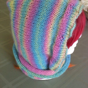 Peut inclure: Une &eacute;charpe &agrave; capuche en tricot ray&eacute;e dans les tons de rose, bleu et jaune.