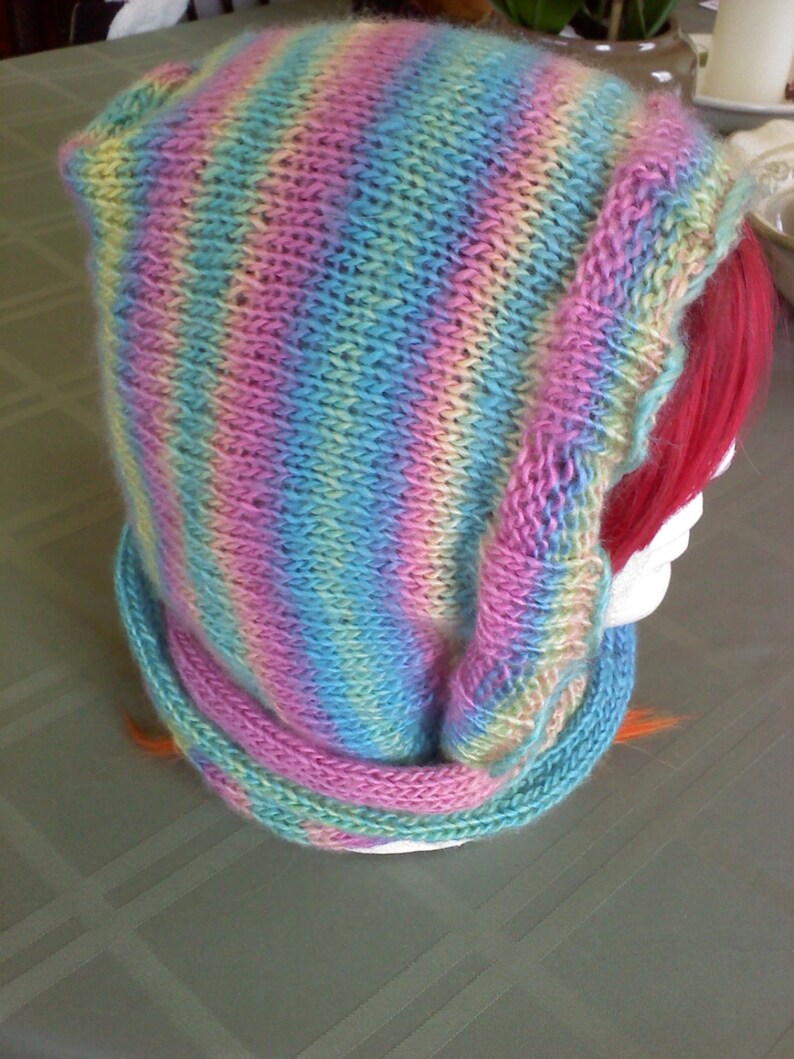 Peut inclure: Une &eacute;charpe &agrave; capuche en tricot ray&eacute;e dans les tons de rose, bleu et jaune.