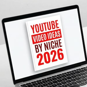 Puede incluir: Un ordenador portátil muestra una portada de libro con el título "YOUTUBE VIDEO IDEAS BY NICHE 2026" en rojo y blanco. Un smartphone muestra una interfaz similar. Una taza y un cuaderno también están en la superficie blanca.