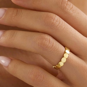 Puede incluir: Una taza de cerámica blanca con un asa negra y el texto "But First, Coffee" en negro, con una fuente de estilo manuscrito. La taza está sobre una superficie blanca.