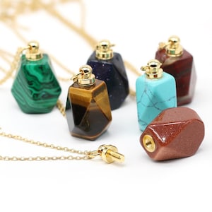 Peut inclure: Plusieurs pendentifs en pierres précieuses de différentes couleurs : vert malachite, bleu, marron œil de tigre, turquoise et rouge-brun. Chaque pendentif est orné d'un capuchon doré et d'une chaîne dorée. Les pendentifs sont facettés et de forme géométrique.